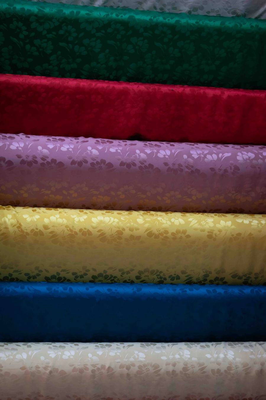 Close-up of colourful fabric rolls with floral woven patterns